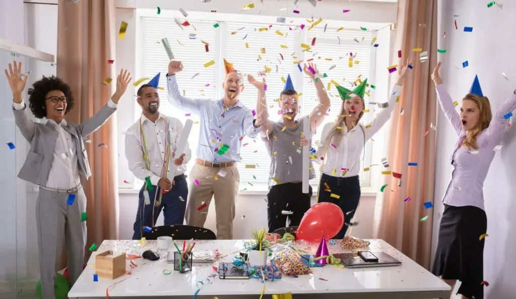 A group of happy employees celebrating a grand opening with confetti A group of happy employees celebrating a grand opening with confetti